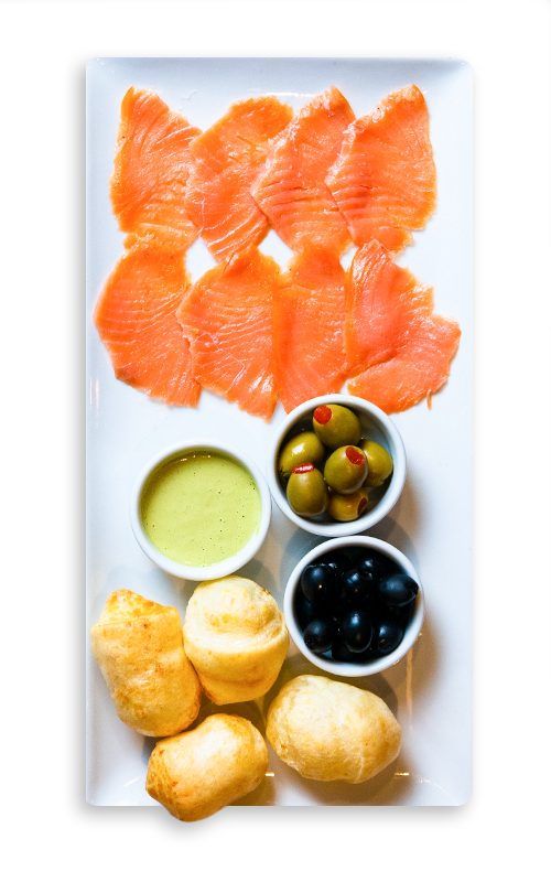 A plate of salmon, olives, and cheese bread