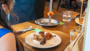 guest being served tableside during all you can eat Brazilian steakhouse experience at Estância with green card turned on